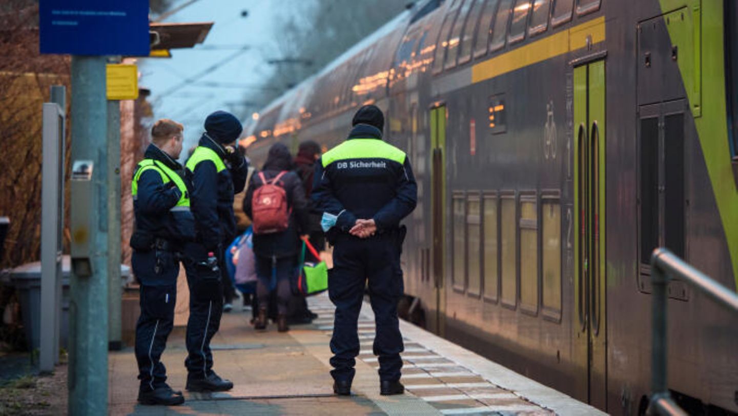 Sicherheitsleute der Deutschen Bahn stehen im Morgengrauen auf dem Bahnsteig in Brokstedt