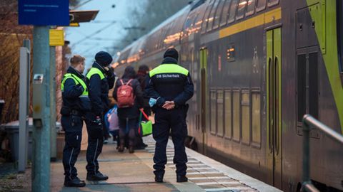 Sicherheitsleute der Deutschen Bahn stehen im Morgengrauen auf dem Bahnsteig in Brokstedt