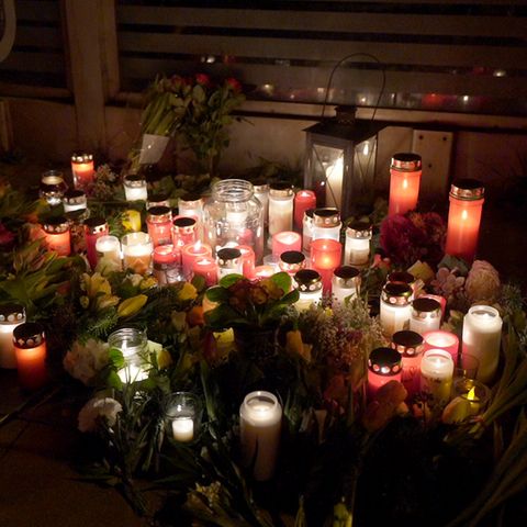 Kerzen und Grablichter erleuchten in Brokstedt den ansonsten dunklen Bahnsteig. Zwischen den Kerzen liegen Blumen
