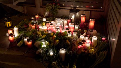 Kerzen und Grablichter erleuchten in Brokstedt den ansonsten dunklen Bahnsteig. Zwischen den Kerzen liegen Blumen