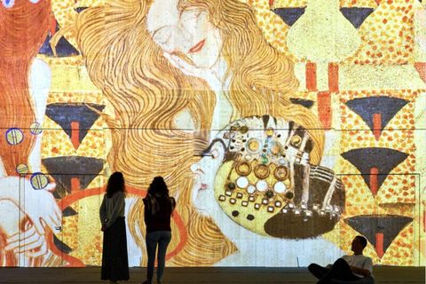 Eintauchen in eine andere Welt: Das ist das Konzept immersiver Ausstellungen, die aktuell  in vielen deutschen Städten zu sehen sind. Der Begriff steht für ein stark wachsendes Genre, das die Betrachter nicht wie üblich auf Abstand hält, sondern sie in das Werk miteinbezieht. Ausstellungen wie "Klimts Kuss", die aktuell in Berlin läuft, locken sie nicht nur Instagram-affine Besucher an, sondern auch diejenigen, die selten in Museen gehen. Die Veranstalter der Shows sehen sich dennoch nicht als Konkurrenz zu klassischen Kunsthäusern, sondern eher als Ergänzung. Vor allem in Zeiten, in denen sich mehrere Museen dem gleichen Künstler widmen, bieten sie eine Möglichkeit, besondere Bilder für alle verfügbar zu machen – wenn auch nur digital.