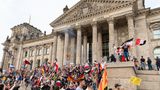Teilnehmer einer Kundgebung gegen die Corona-Maßnahmen stehen auf den Stufen zum Reichstagsgebäude