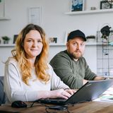 Ein junges Paar vor ihren Laptops