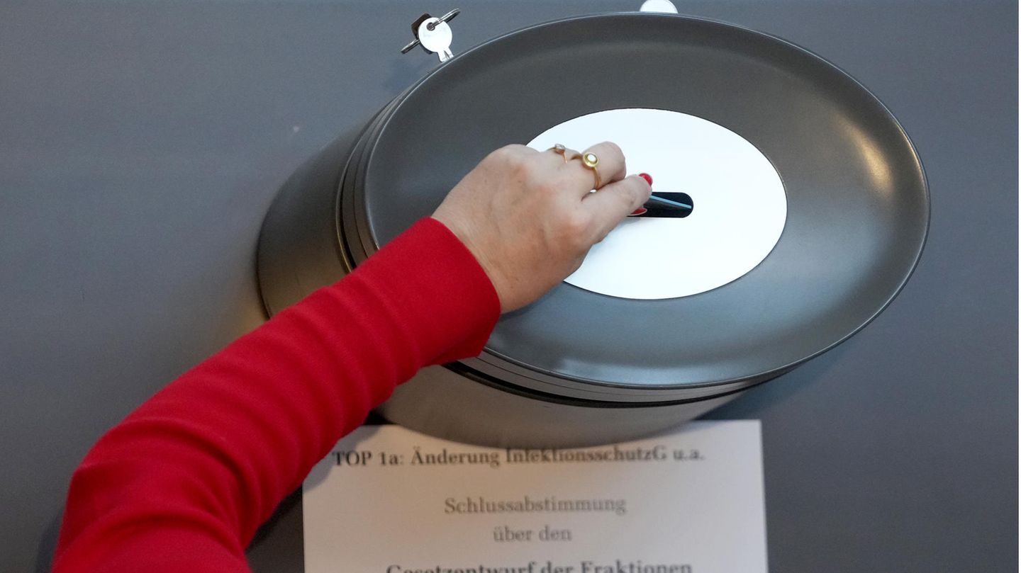 Arm einer Abgeordneten, die ihre Stimme zum Infektionsschutzgesetz in die Wahlurne wirft