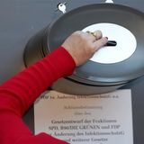 Arm einer Abgeordneten, die ihre Stimme zum Infektionsschutzgesetz in die Wahlurne wirft