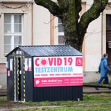 Corona: Ein Mann geht in Potsdam hinter einer in einer kleinen Hütte untergebrachten Covid-19-Teststation vorbei.