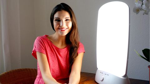 Deals des Tages: Eine Frau sitzt vor einer Tageslichtlampe
