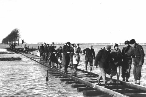 Bewohner des niederländischen Überschwemmungsgebietes in Zeeland an der Nordsee überqueren einen Schienenstrang