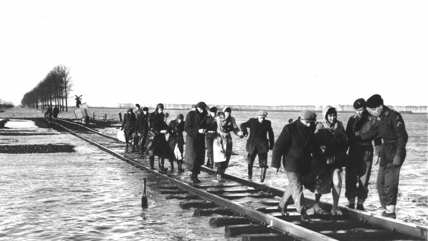 Bewohner des niederländischen Überschwemmungsgebietes in Zeeland an der Nordsee überqueren einen Schienenstrang