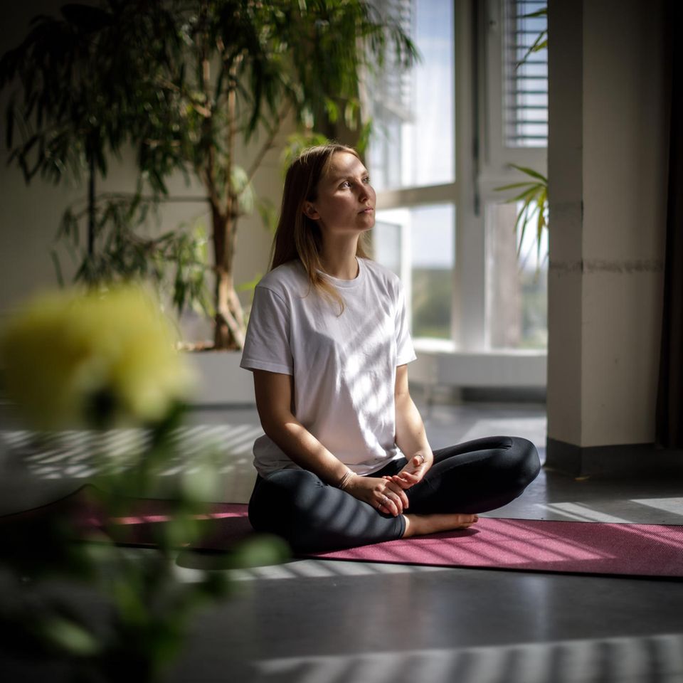 Die Psychologin Inge Maria Hahne sitzt auf einer Yogamatte in der offenen Psychose-Station der Berliner Charité