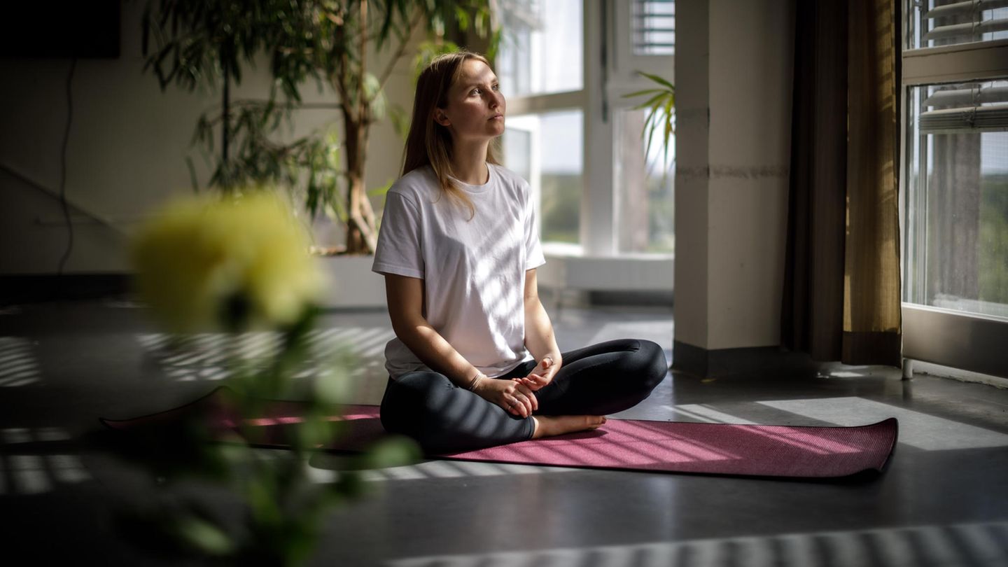 Die Psychologin Inge Maria Hahne sitzt auf einer Yogamatte in der offenen Psychose-Station der Berliner Charité