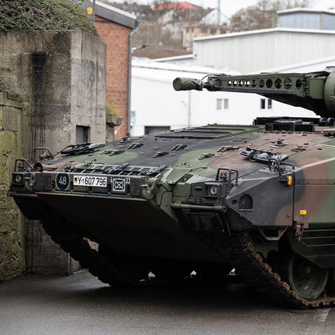 Ein Schützenpanzer "Puma" in Tarnfleck und dem Kreuz der Bundeswehr steht auf einem Fabrikgelände