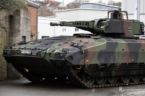 Ein Schützenpanzer "Puma" in Tarnfleck und dem Kreuz der Bundeswehr steht auf einem Fabrikgelände