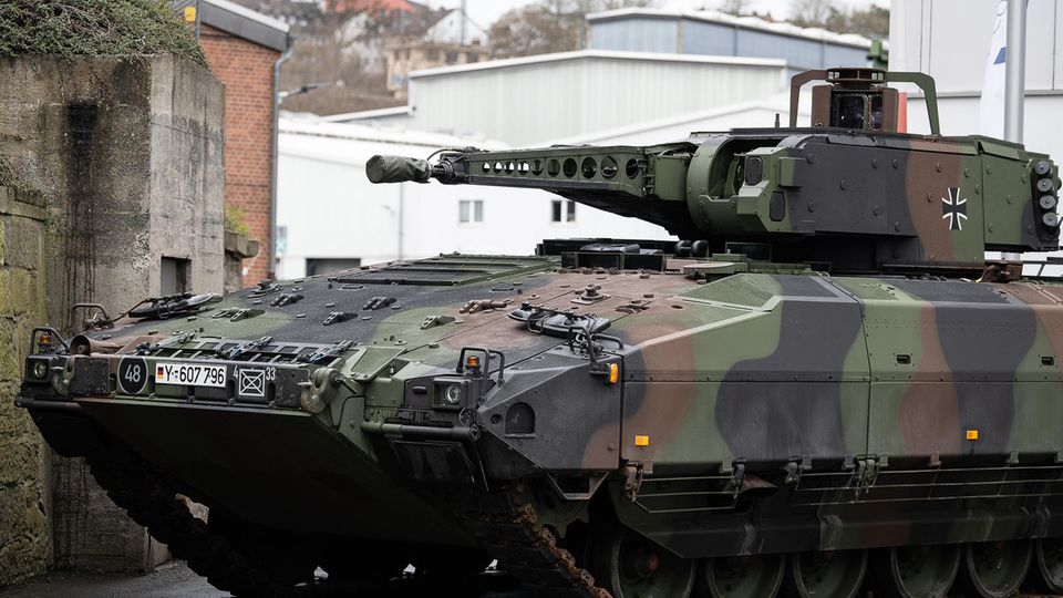 Ein Schützenpanzer "Puma" in Tarnfleck und dem Kreuz der Bundeswehr steht auf einem Fabrikgelände