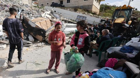 Palästinenser vor dem zerstörten haus des Attentäters, der sieben Juden nach einem Gottesdienst tötete