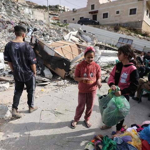Palästinenser vor dem zerstörten haus des Attentäters, der sieben Juden nach einem Gottesdienst tötete