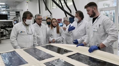 Ein Forschungsteam ist um Solarpanels versammelt. Es möchte Photovoltaik in Masse produzieren.