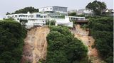 Auckland, Neuseeland. Gefährlich nah stehen diese Häuser an der Klippe. Die größte Stadt des Landes wurde von sintflutartigen Regenfällen heimgesucht, die Überschwemmungen verursachten und Erdreich mitrissen. Vier Menschen starben. Es soll in der Region weiter regnen.