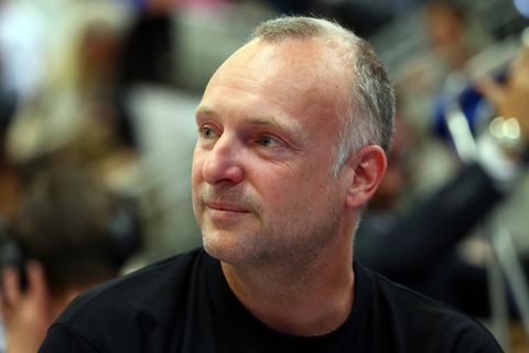 Frank Buschmann, ein weißer Mann mit grau-blondem Kurzhaarschnitt, hat seinen Kopf nach rechts gedreht und lächelt leicht