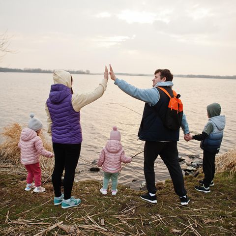 Patchworkfamilie geben sich High Five an einem See