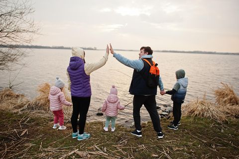 Patchworkfamilie geben sich High Five an einem See