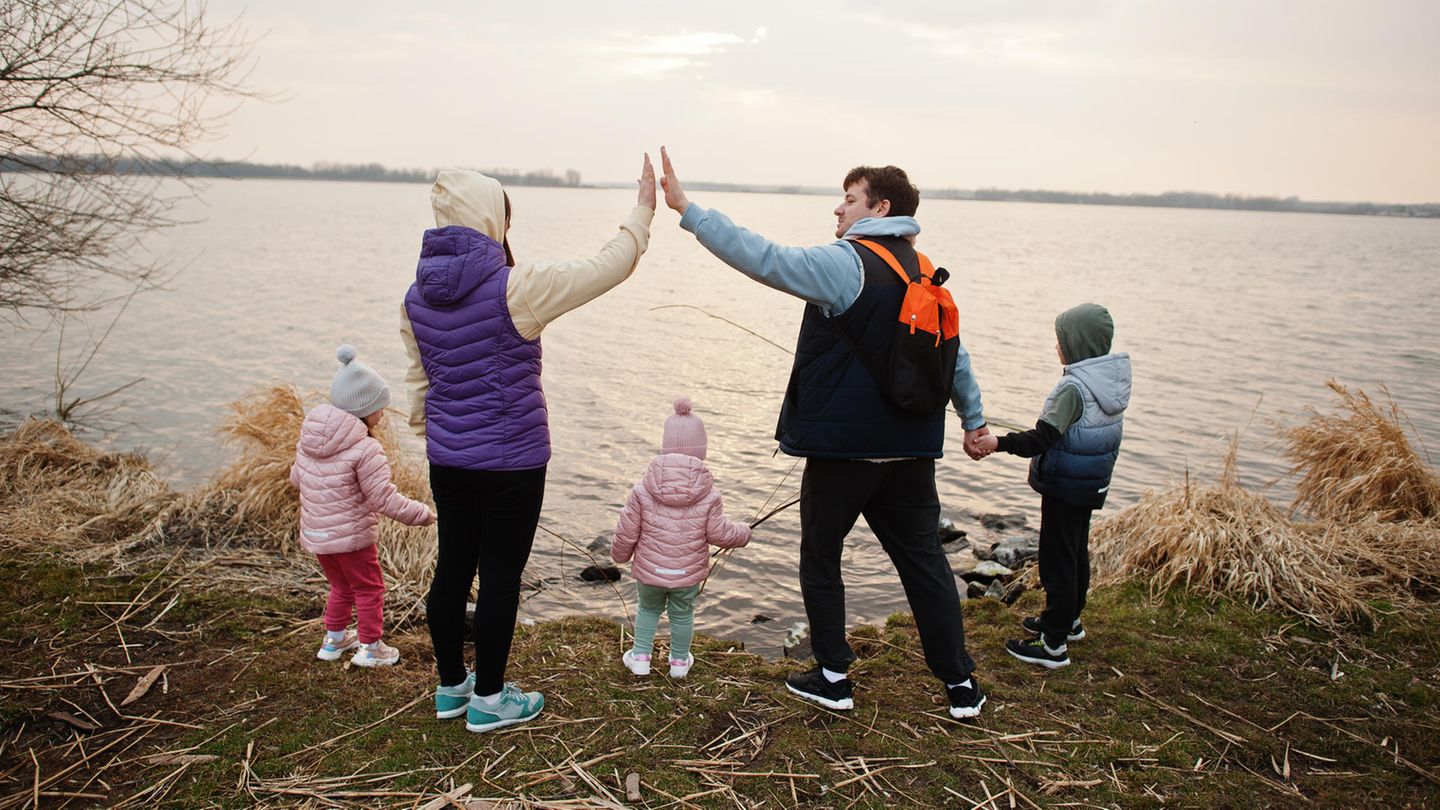 Patchworkfamilie geben sich High Five an einem See