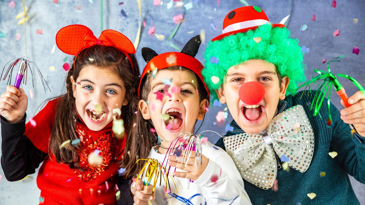 Kinder gucken am Kinderfasching verkleidet in die Kamera
