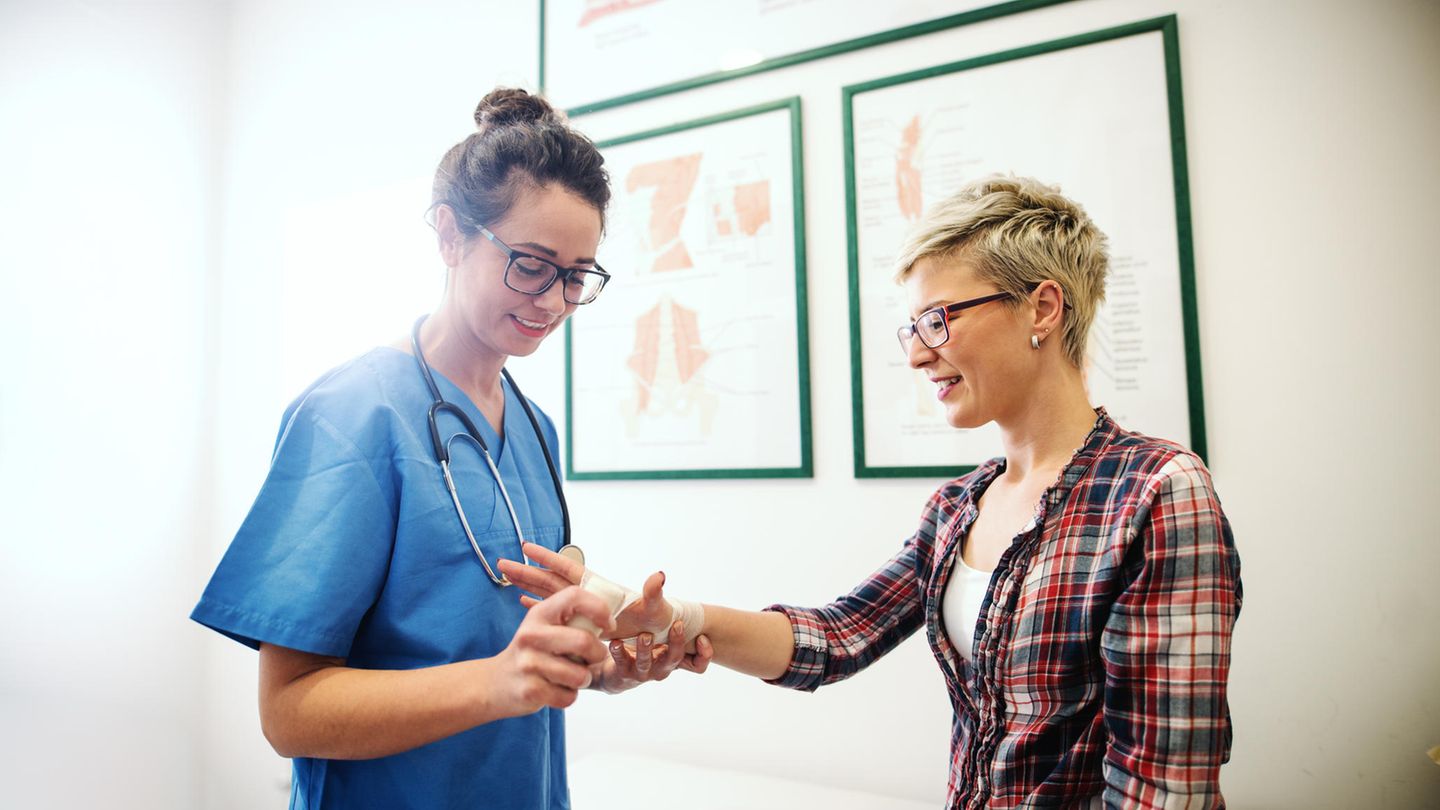 Frau untersucht die Hand einer anderen Frau
