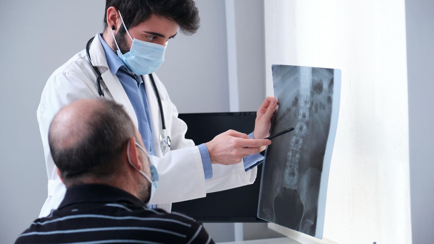 Arzt unterhält sich mit Patient über Röntgenbilder