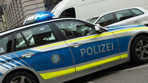 Ein Polizeiauto mit Blaulicht steht auf einer Straße. Ein Mann aus Augsburg hortete zahlreiches Diebesgut in seinem Haus.
