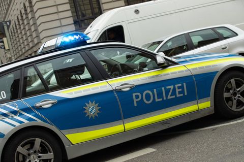 Ein Polizeiauto mit Blaulicht steht auf einer Straße. Ein Mann aus Augsburg hortete zahlreiches Diebesgut in seinem Haus.