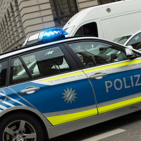 Ein Polizeiauto mit Blaulicht steht auf einer Straße. Ein Mann aus Augsburg hortete zahlreiches Diebesgut in seinem Haus.