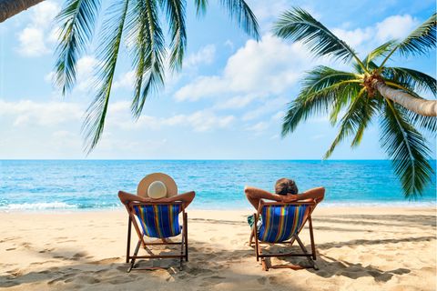 Zwei Männer sitzen entspannt am Strand auf Liegestühlen