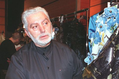 Modedesigner Paco Rabanne steht neben einem Kleiderständer mit einigen seiner Kreationen
