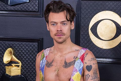 Ausnahmekünstler Harry Styles präsentiert seine Tattoos in einem weit ausgeschnittenen Glitzer-Anzug. 