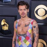 Ausnahmekünstler Harry Styles präsentiert seine Tattoos in einem weit ausgeschnittenen Glitzer-Anzug. 