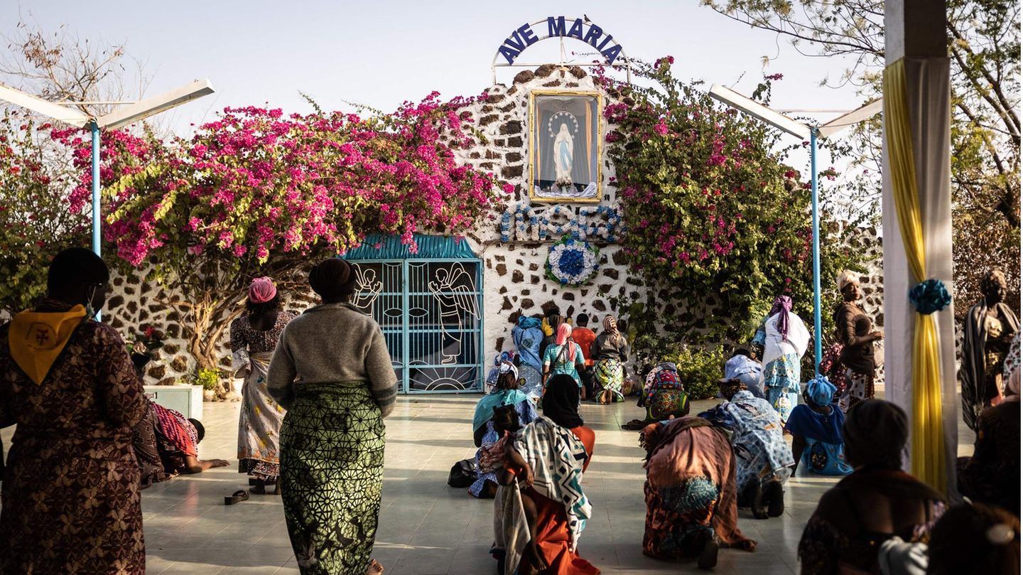 Ouagadougou, Burkina Faso. Pilger beten vor der Grotte des Marienheiligtums in Yagma, einem kleinen Dorf am Stadtrand von Ouagadougou. Tausende Gläubige aus mehreren Diözesen Burkina Fasos brechen alle drei Jahre zu einer nationalen Pilgerreise auf, um für Frieden zu beten. 