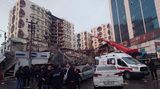 Rettungskräfte und medizinische Teams versuchen verschüttete Bewohner aus einem eingestürzten Gebäude zu retten