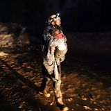 Ein Mitglied des syrischen Zivilschutzes trägt ein kleines Kind, das gerettet wurde