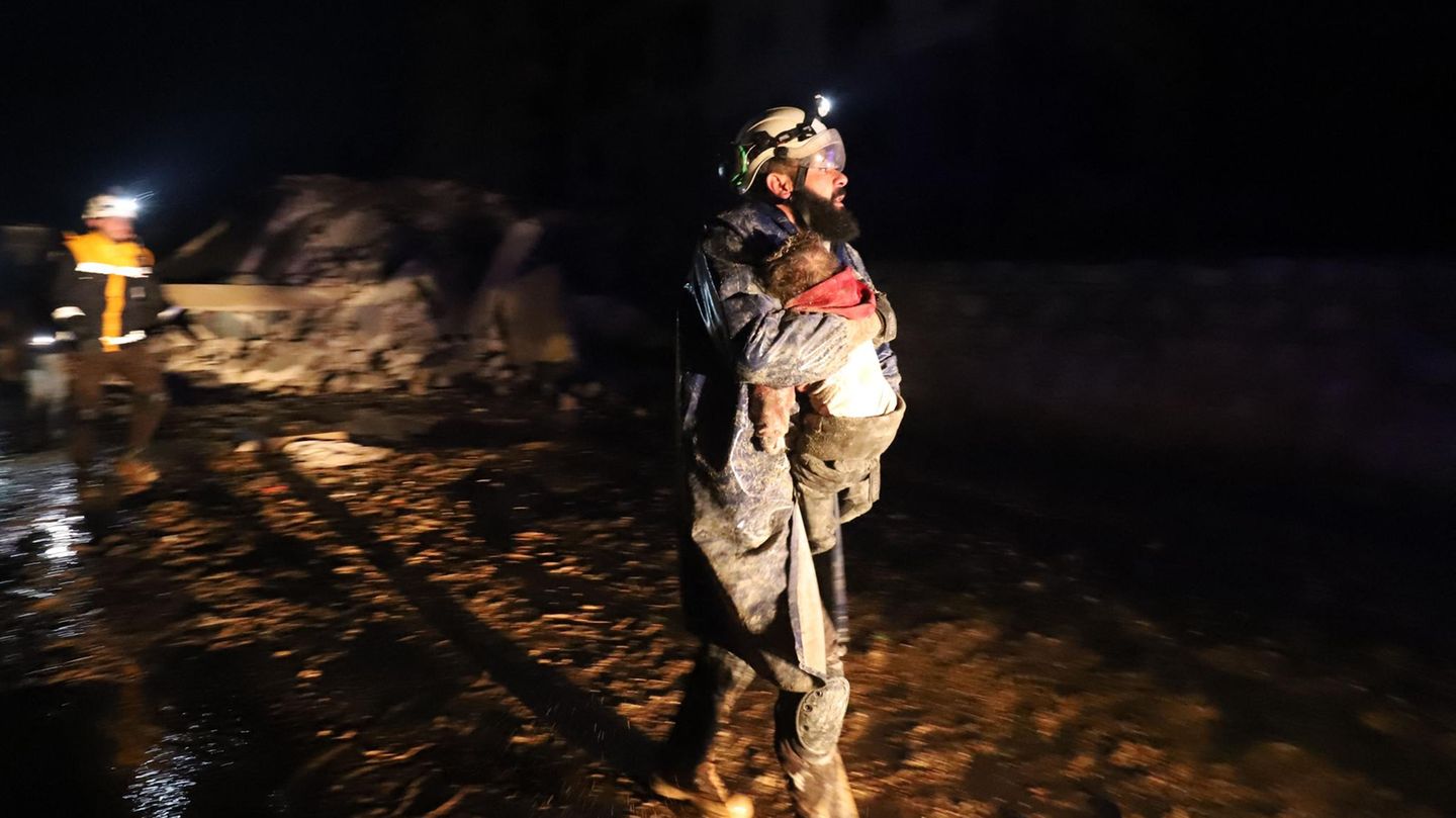 Ein Mitglied des syrischen Zivilschutzes trägt ein kleines Kind, das gerettet wurde Ein Mitglied des syrischen Zivilschutzes trägt ein kleines Kind, das gerettet wurde