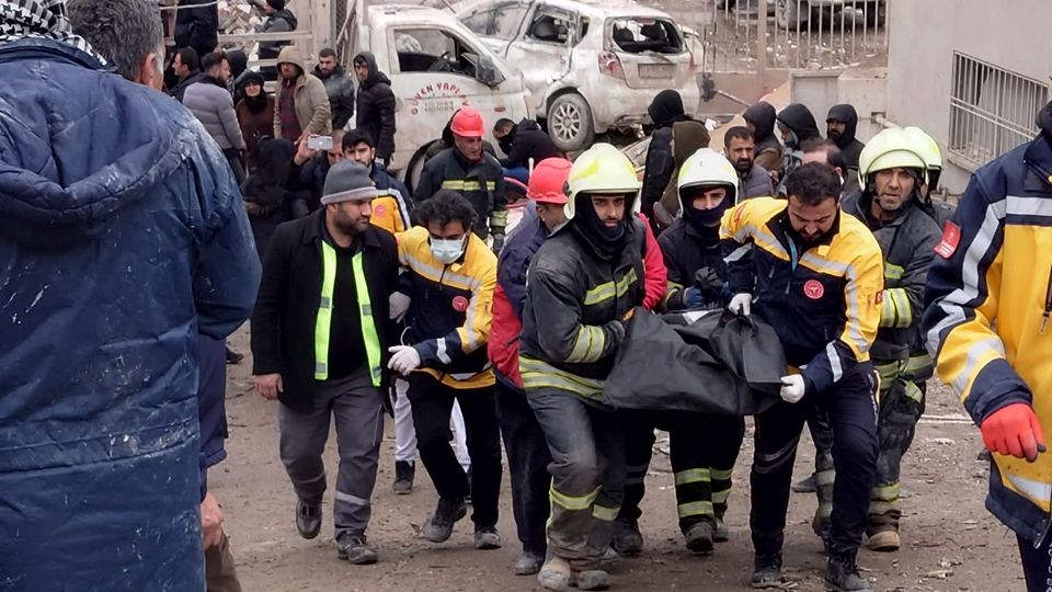Feuerwehrleute tragen die Leiche eines Opfers Feuerwehrleute tragen die Leiche eines Opfers