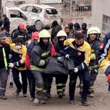 Feuerwehrleute tragen die Leiche eines Opfers
