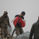 Ein syrischer Mann trägt die Leiche eines Kleinkinds