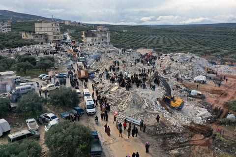 Zivilschutzmitarbeiter und Anwohner durchsuchen im syrischen Harem die Trümmer eingestürzter Gebäude nach Überlebenden