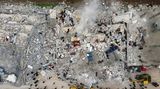 Diese Luftaufnahme zeigt Anwohner, die nach Opfern und Überlebenden in den Trümmern eingestürzter Gebäude suchen