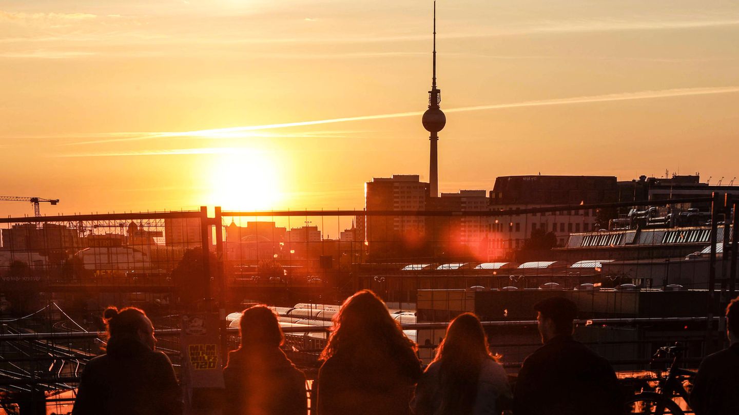 Menschen sehen sich den Sonnenuntergang in Berlin an