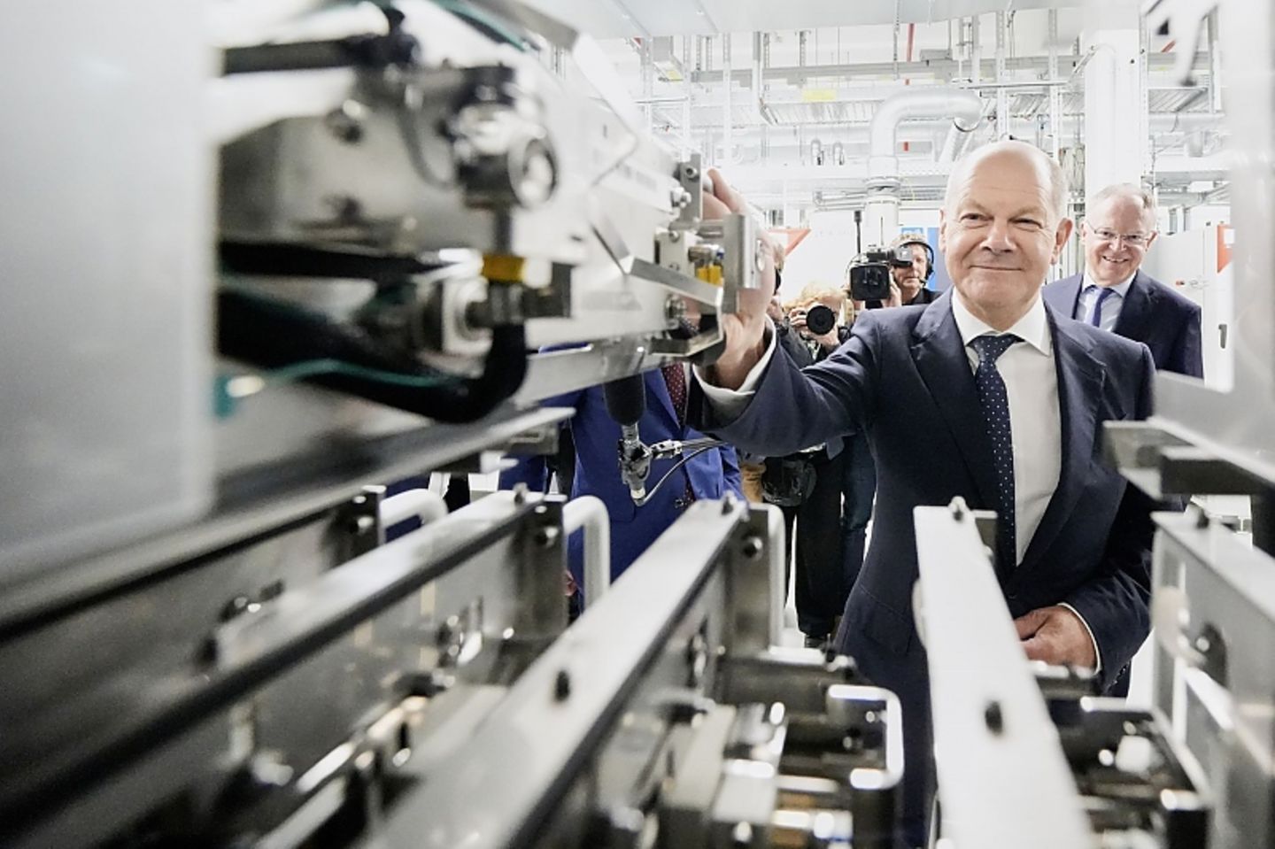 Bundeskanzler Olaf Scholz (vorne) und der niedersächsische 
Ministerpräsident Stephan Weil (hinten rechts) bei VW