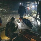 Nur mit einer Folie vor dem Schnee gedeckt behandeln Retter eine verletzte Person auf offener Straße in Hatay