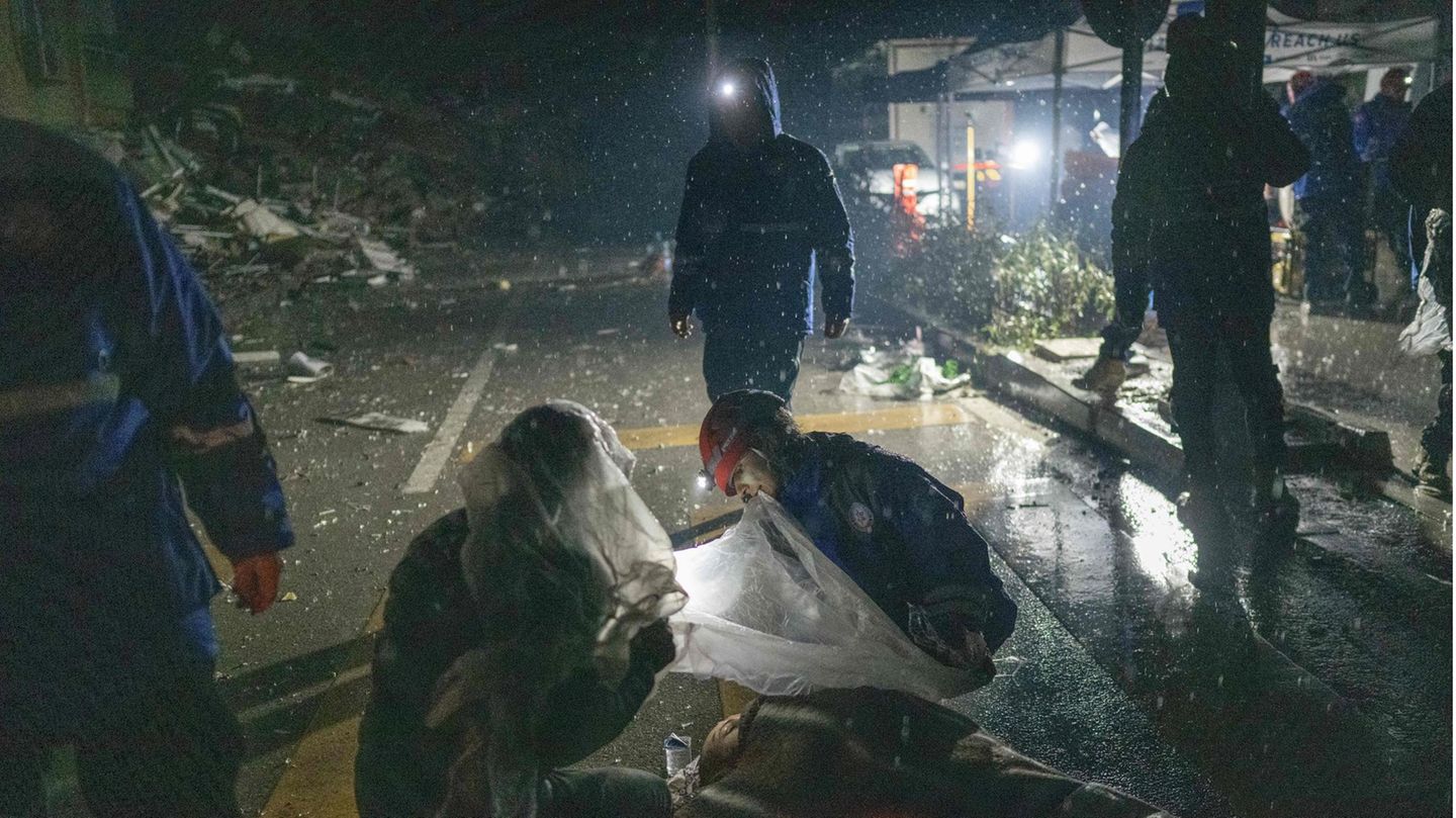 Nur mit einer Folie vor dem Schnee gedeckt behandeln Retter eine verletzte Person auf offener Straße in Hatay