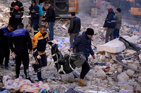 Adana in der Türkei: Zwei Männer tragen eine Leiche aus einem zerstörten Gebäude.